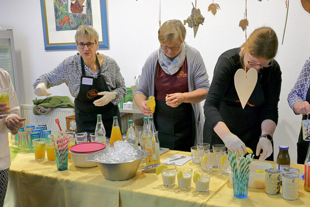 Ehrenamtliche beim Zubereiten von bunten Cocktails