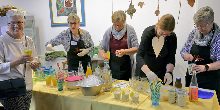 2024_10_Faire Cocktails zum Jubiläum Ehrenamtliche beim Zubereiten von bunten Cocktails