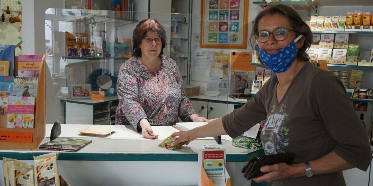 Ob mit oder ohne Mundschutz – durch die Wiederaufnahme des Verkaufs im Esperanza-Weltladen hier mit Karin Roth hinter der Theke, ist für die Produzenten in den Ländern des Südens der Absatz ihrer Waren gesichert.