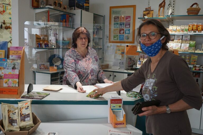 Ob mit oder ohne Mundschutz – durch die Wiederaufnahme des Verkaufs im Esperanza-Weltladen hier mit Karin Roth hinter der Theke, ist für die Produzenten in den Ländern des Südens der Absatz ihrer Waren gesichert.